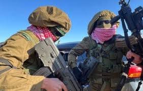 عناصر حماس يظهرون بزي عسكري إسرائيلي أثناء تسليم الأسرى.. صور